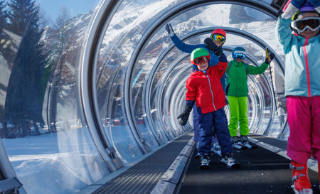 Colorful happy skiers family enjoys the snowy mountain liftの写真素材