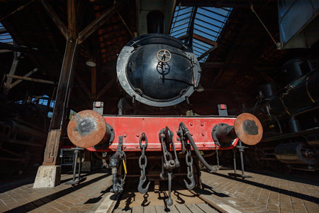 Steam engine viewed inside shed showcasing boiler and mechanics
