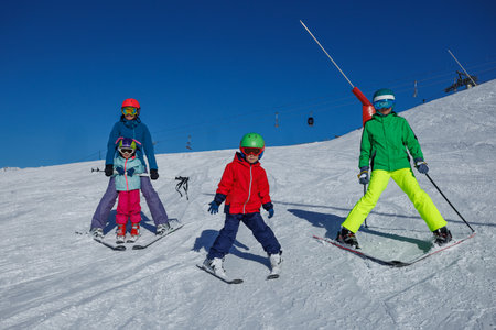 Young skier in red jacket glides down slope under vivid blue skyの写真素材
