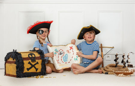 Kids boy and girl smile, dressed as pirates with treasure mapの写真素材