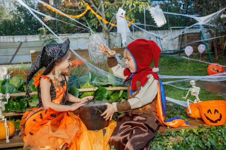 Kids, boy, girl enjoy Halloween fun, dressed as witch and elfの写真素材
