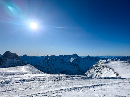 Snow-covered mountain peaks. sun shines brightly on blue sky