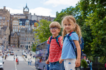 Kids with backpacks stand on a street of Edinburgh, Scotlandの写真素材
