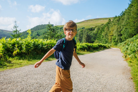 Child boy enjoying a sunny walk on countryside trail in Englandの写真素材
