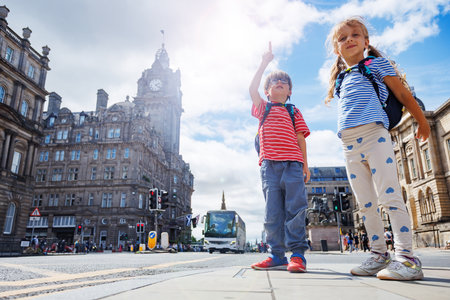 Children tourist in colorful clothes enjoy sights of Edinburghの写真素材