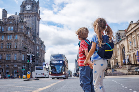 Children with backpacks cross a busy city street, hold handsの写真素材