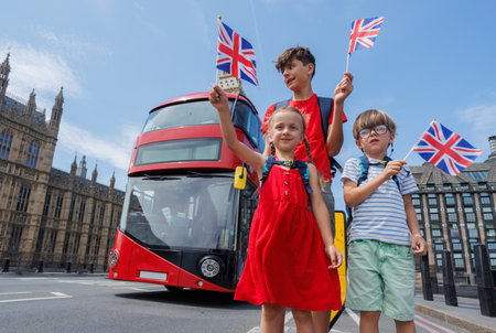 Happy tourists kids group posing in front of Big Ben and red busの写真素材