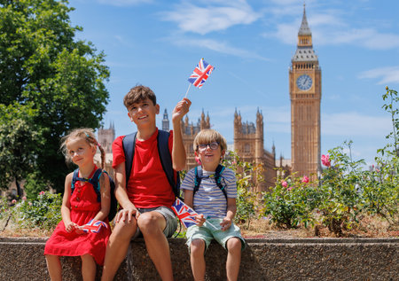 Group of happy kids with UK flags enjoy visiting London downtownの写真素材