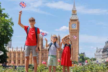 Children on summer trip in London waving UK flags before Big Benの写真素材