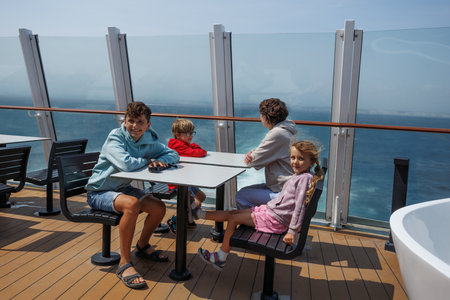 Family enjoying the sea view from a deck, kids looking excited