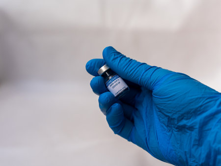 A doctor holds a dose of a recently developed COVID-19 vaccine ready to inject in a patient's arm in order to provide immunity against this conditionの写真素材