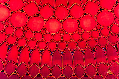 Red wall and ceiling in the main pavilion of Expo 2020 forming an intricate geometric shape.の写真素材