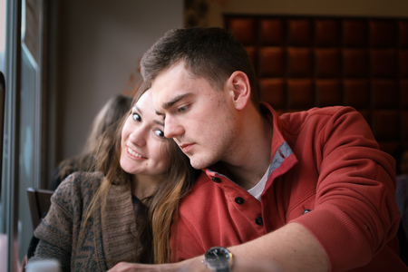 Young couple in a restaurant sitting at a table by the window and make an order. Two personsの写真素材