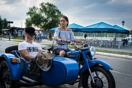 Young couple is traveling on a retro motorcycle. Beautiful woman with boyfriend went in road trip....