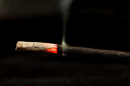 Macro of incense and smoke particles on black backgroudの写真素材