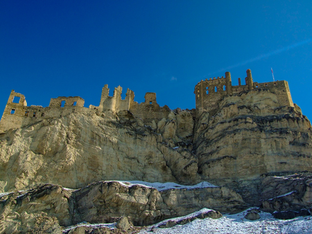 A castle on top of the mÄ±ountain.The The view of snowy mountains and peak with blue sky and cloudsの写真素材