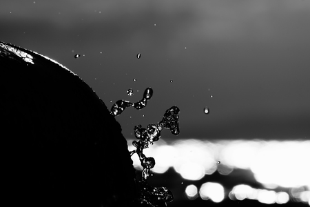 Sea wave crashing on rock. Black and white art of drops.の写真素材