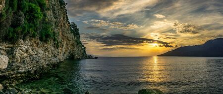 Beautiful sunset over the sea with mountain and cloudy sky. Marmaris, Kumlubuk, Turkey. Panoramic landscape.の写真素材