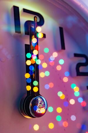 Close up Christmas composition with alarm clock and reflection of bokeh lights from clock glass....