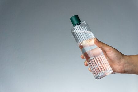 Woman holding Turkish cologne (or eau de cologne) on her hand. Coronavirus transmission with hands. Covid19 conceptの写真素材