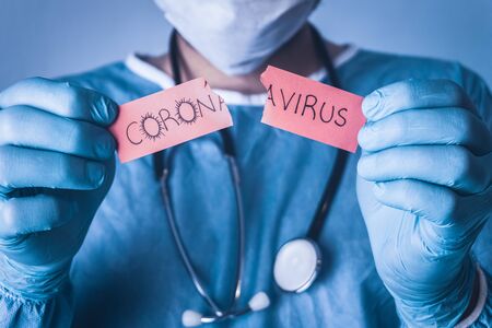 The doctor tears off the white paper that says Coronavirus. Coronavirus outbreak concept.