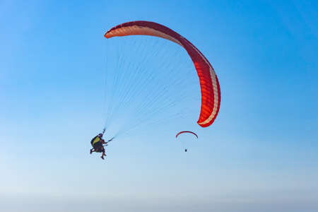 Paragliding in the sky. Paraglider tandem flying over the sea with mountains at sunset. Aerial view of paraglider and Blue Lagoon in Oludeniz, Babadag, Mugla, Turkey.のeditorial素材