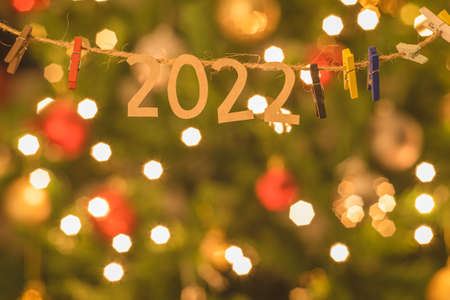 2022 Happy New Year. Christmas concept and background with pine tree branches, lights and balls.