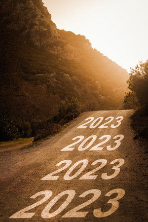 2023 written on forest road at sunset. Concept for new year 2023.の写真素材