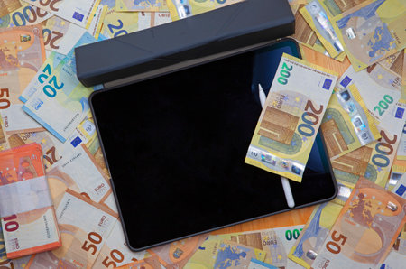 a tablet device with euro banknotesの写真素材