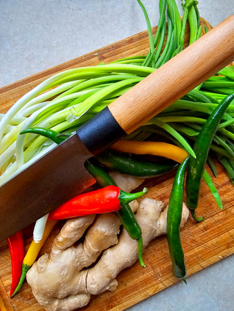 Fresh vegetables and knife on a cutting board.