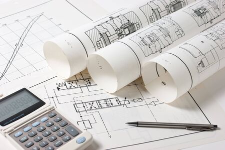 rolled technical drawings and a calculatorの写真素材