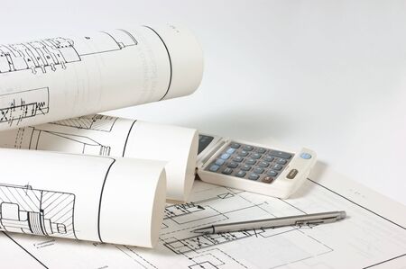 rolled technical drawings and a calculatorの写真素材