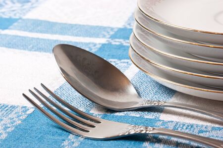 fork and spoon stack of plates on the tableの写真素材