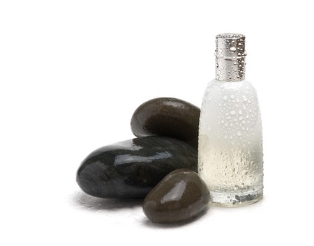 bottle of cologne wet and pebbles isolated on a white backgroundの写真素材