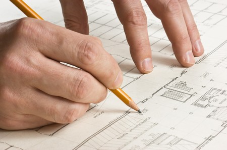 hand draws a pencil on the drawing