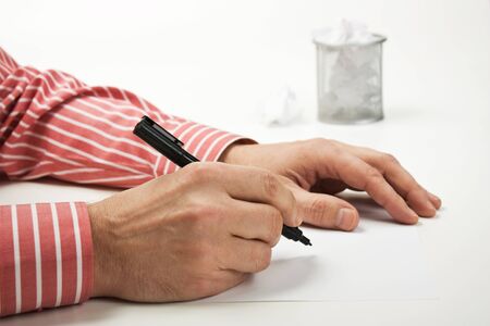 pen in hand and a basket for paperの写真素材