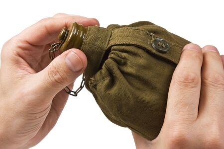 hiking flask in hand isolated on white backgroundの写真素材