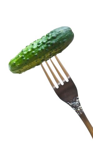 fresh green cucumber at the fork isolated on whiteの写真素材