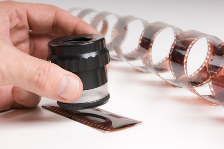hand holding a magnifying glass and twisted filmの写真素材