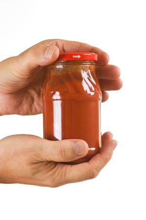jar tomato paste in hand isolated on white backgroundの写真素材