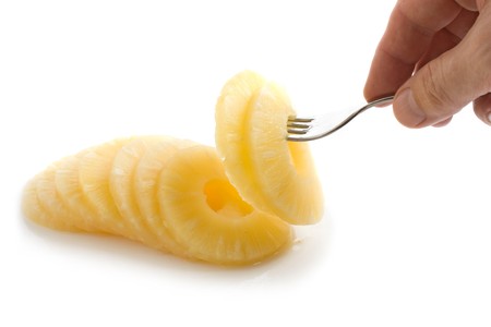 slice of pineapple on a fork  isolated on white backgroundの写真素材