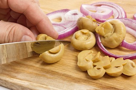 sliced mushrooms and onions on a cutting boardの写真素材