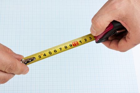 Measuring tape in hand on graph paper