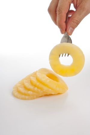slice of pineapple on a fork  isolated on white backgroundの写真素材