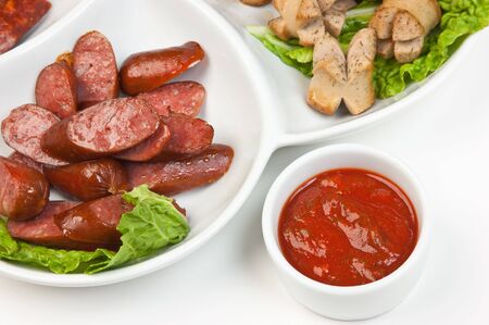 chopped sausages fried with vegetables and spices  isolated on white backgroundの写真素材