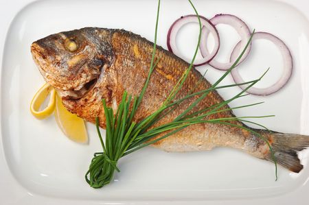 dish of fried fish with onions  isolated on white backgroundの写真素材