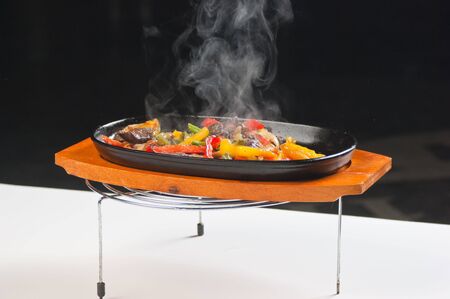 grilled meat with mushrooms and vegetables in a boiling panの写真素材