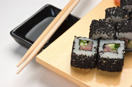 Traditional Asian food sushi on wooden plate isolated on white backgroundの写真素材