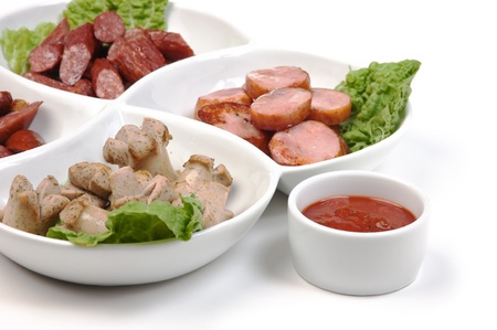 chopped sausages fried with vegetables and spices  isolated on white backgroundの写真素材