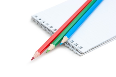 red  green blue pencils and notebook isolated on a white  backgroundの写真素材